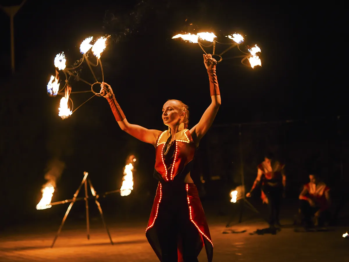Artista realizando un número escénico con fuego sobre la pista del circo